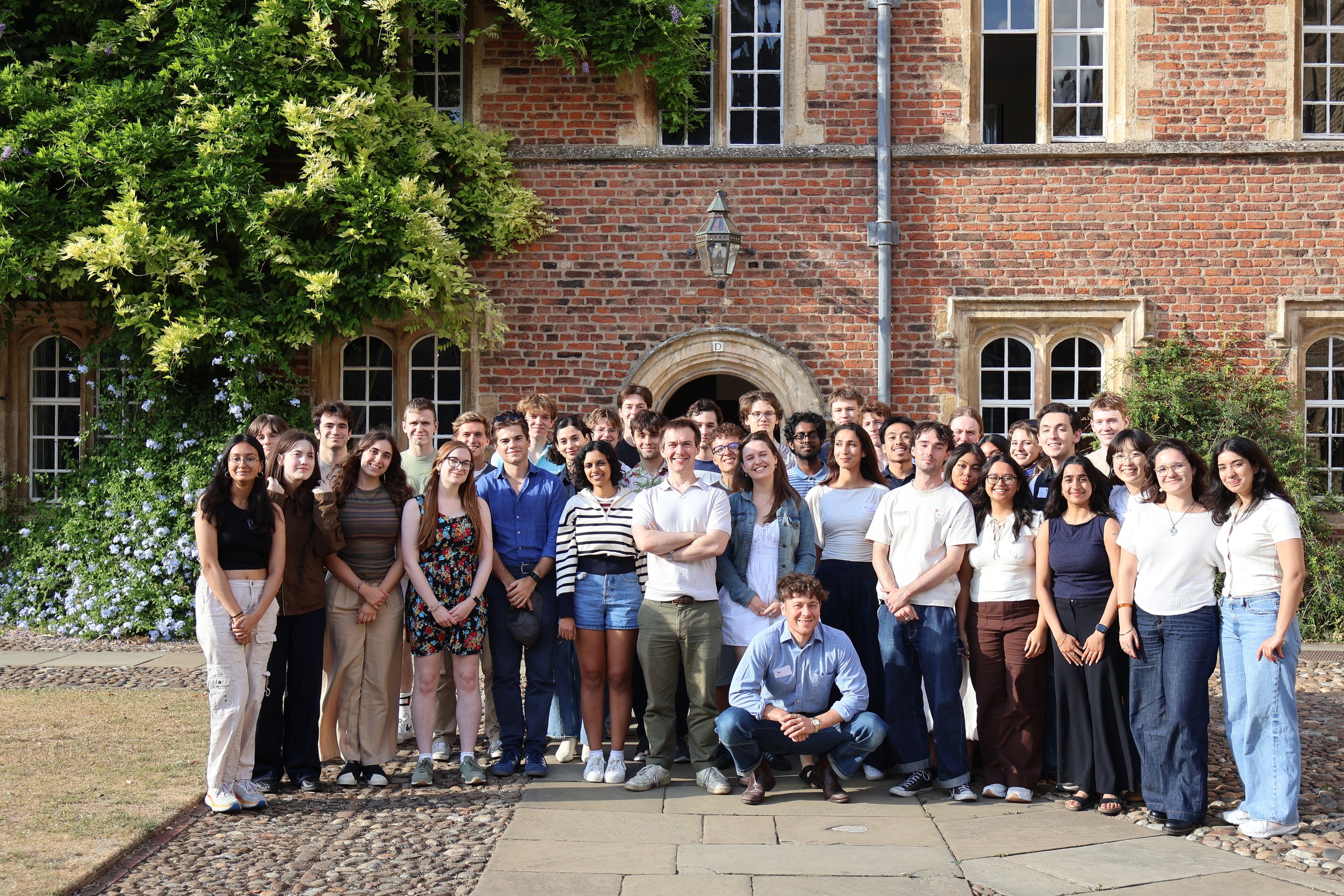 The Invisible College group in a sunny Cambridge college courtyard.